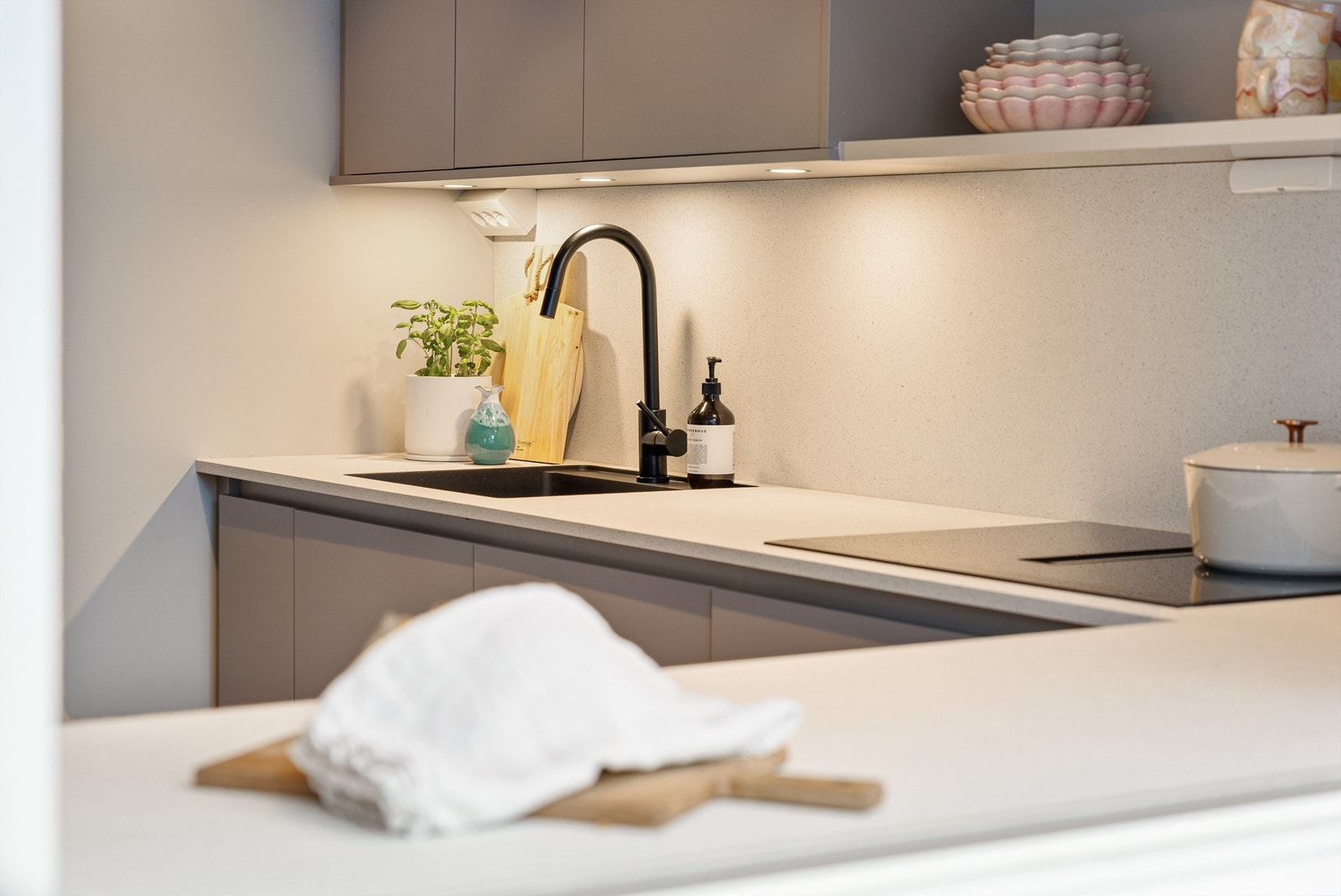 Det er og montert laminert plate mellom benkeplate og overskap som gir både fint estetisk preg og praktisk i forhold til renholdet Galleribilde