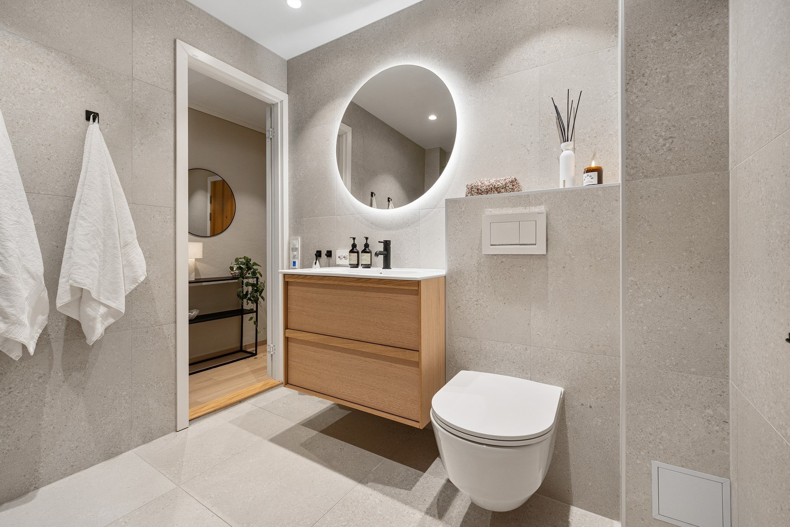 Badet er moderne og gjennomført med delikat materialvalg. Store, lyse fliser i trendy steinimitasjon i 60x60 format gir rommet et eksklusivt uttrykk og skaper en behagelig og rolig atmosfære. Baderomsinnredningen er fra HAVEN Galleribilde