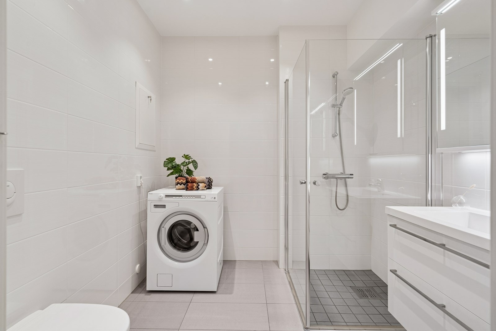 Opplegg for vaskemaskin og dusjhjørne gir praktiske løsninger på baderommet. Galleribilde