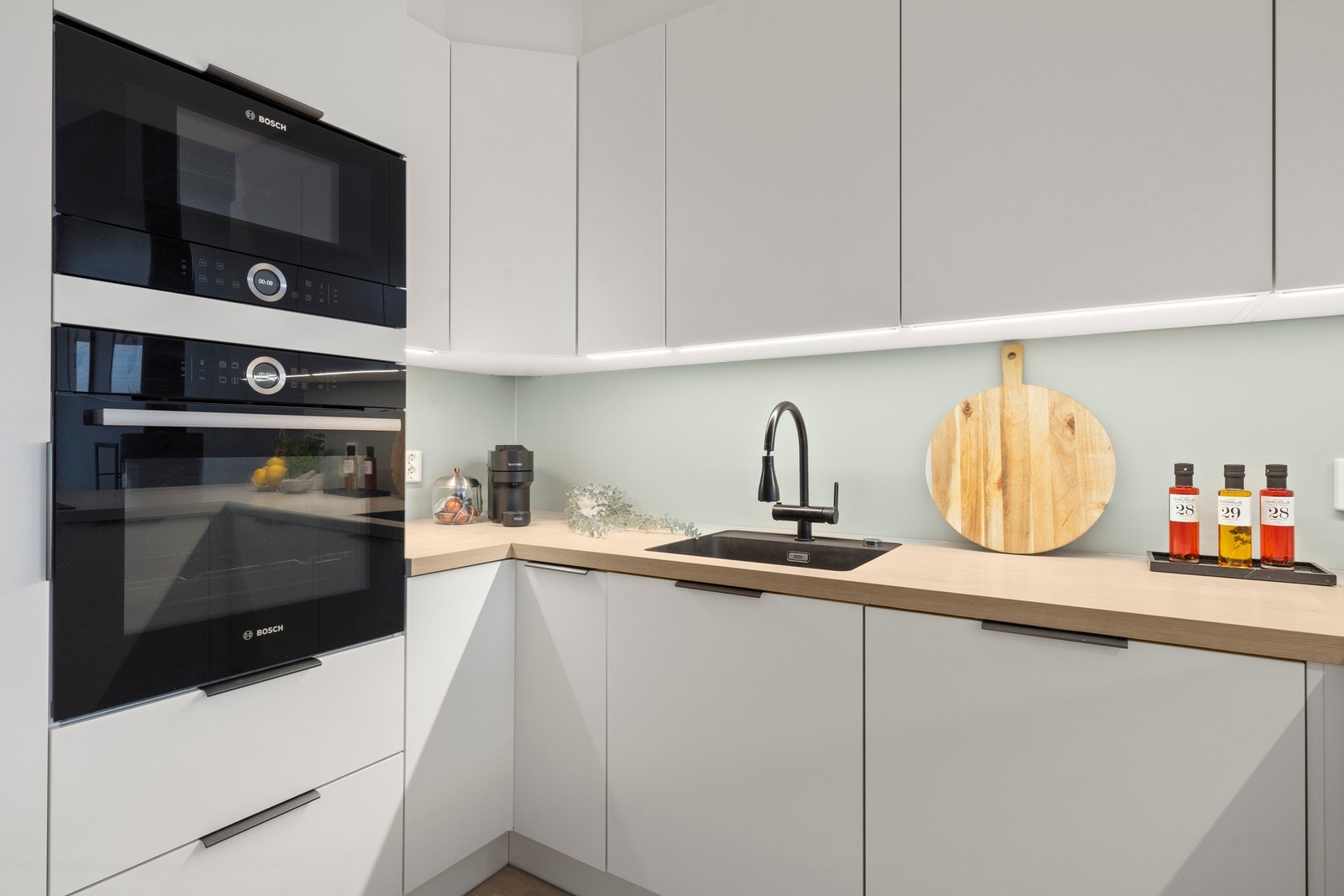 Stilrent kjøkken med gjennomgående moderne uttrykk og solide materialvalg. Kvalitetshvitevarer fra Bosch er integrert på en elegant måte, kombinert med rikelig skapplass, gode arbeidsflater og en helhet som vitner om høy standard og gjennomtenkt design. Galleribilde