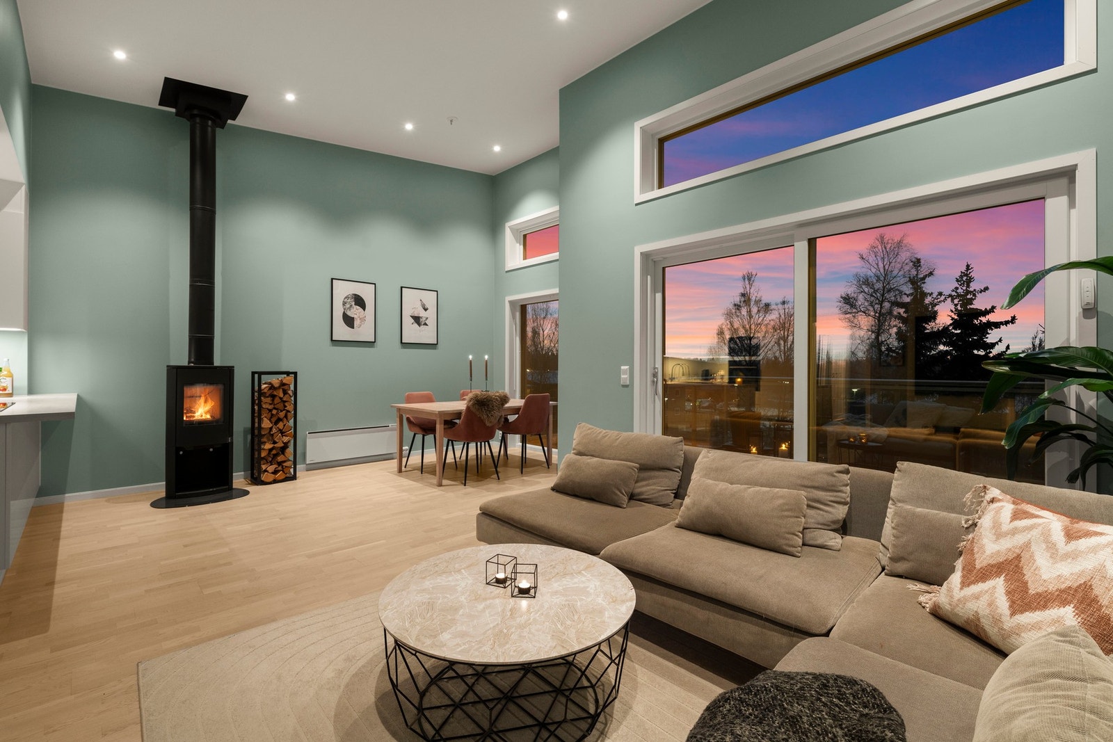 Romslig og elegant stue med store vindusflater, stemningsfull peisovn og integrert spiseplass. Utvendig solskjerming bidrar til god komfort og et behagelig inneklima, samtidig som skyvedør gir enkel adkomst til balkong og uteplass. Galleribilde