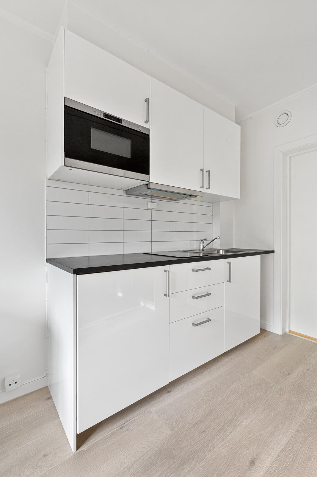 Kjøkkenkrok med koketopp, kjøl-/fryseskap og mikrobølgeovn Galleribilde