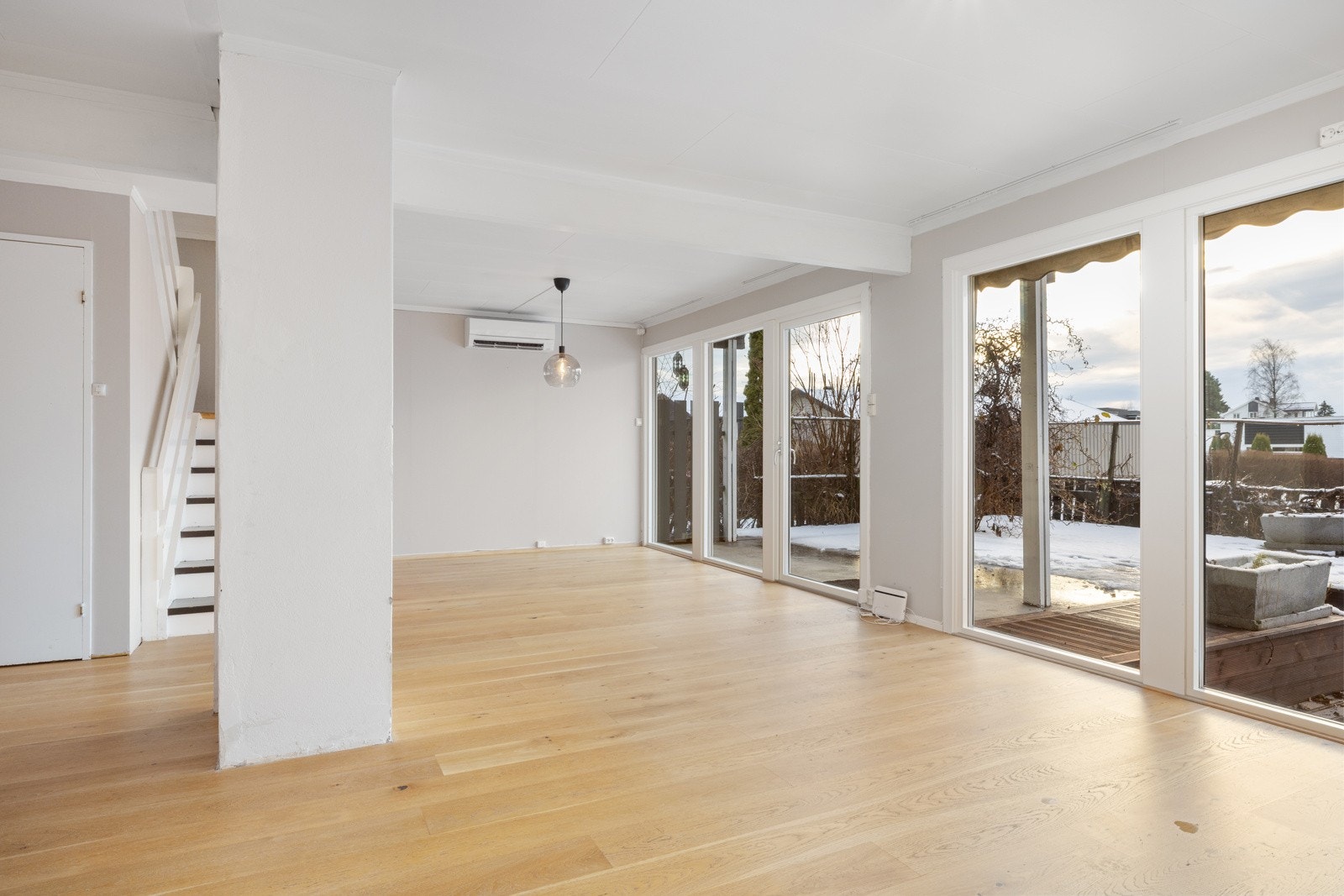 Romslig oppholdsrom i åpen løsning med store vinduer som gir rikelig med lys og en luftig romfølelse. Galleribilde