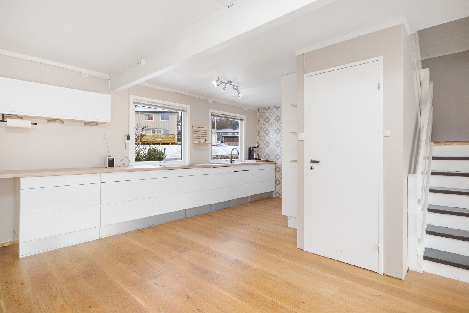 Moderne kjøkken i åpen løsning som gir en luftig og sosial atmosfære, med gode arbeidsflater og naturlig sammenheng med oppholdsrom. Galleribilde