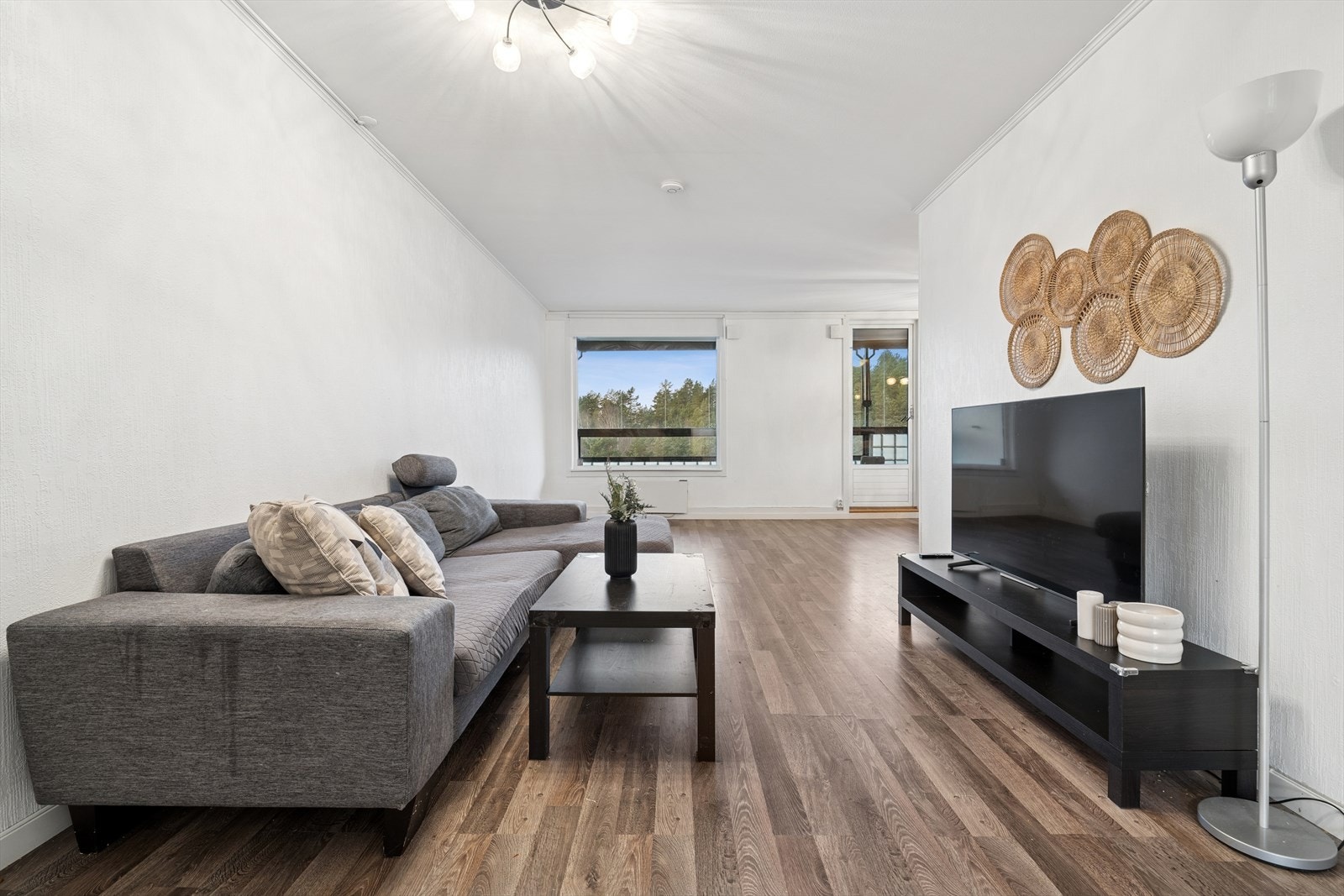 Stuen har godt med plass til å innrede med en sofagruppe med tilhørende stuebord, mediemøbler og en romslig spisestue ved vindu ved kjøkkenet Galleribilde