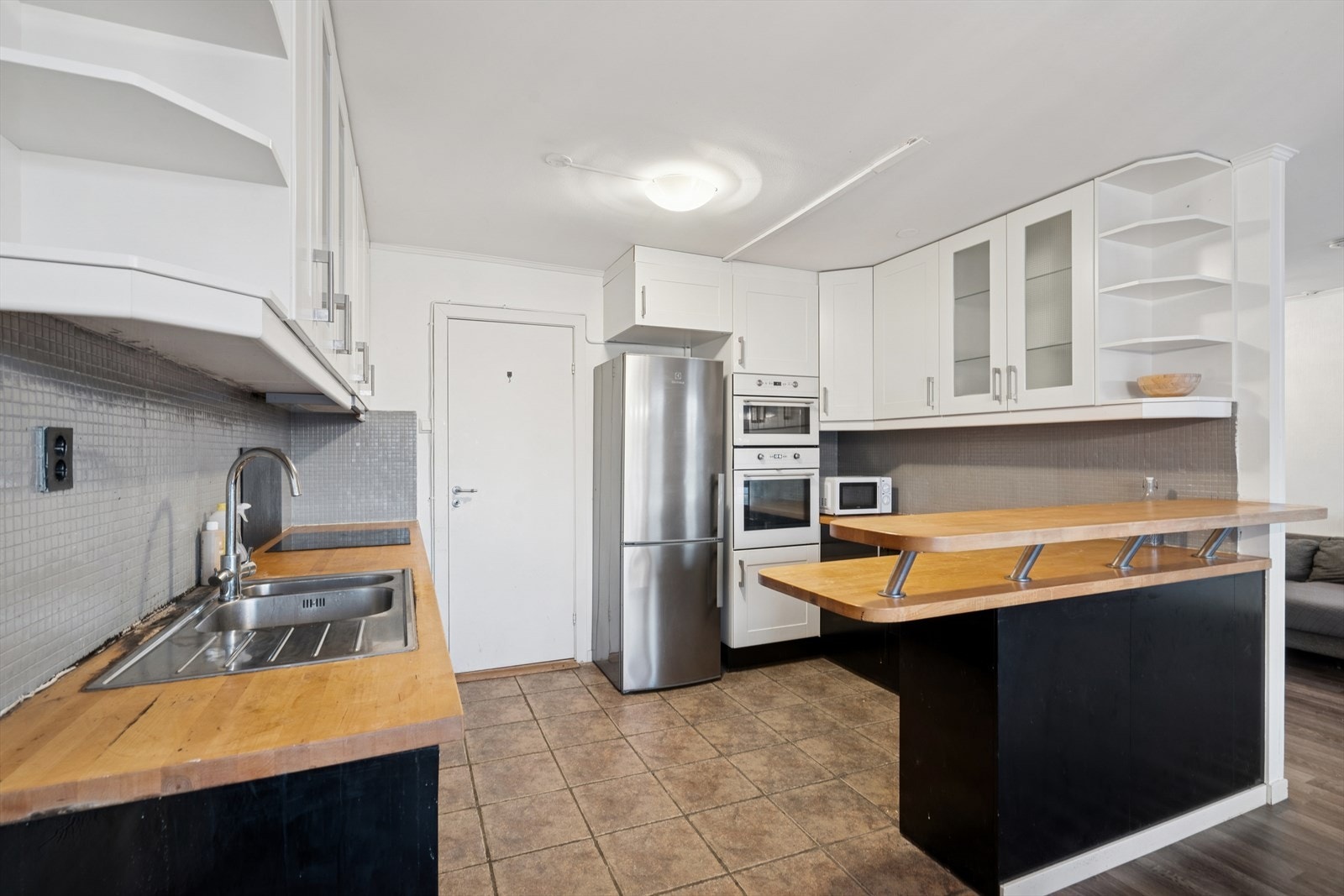 Kjøkkenet har en delvis åpen planløsning sammen med stuen og har i tillegg adkomst fra gangen, noe som gir leiligheten en god gjennomgående planløsning Galleribilde