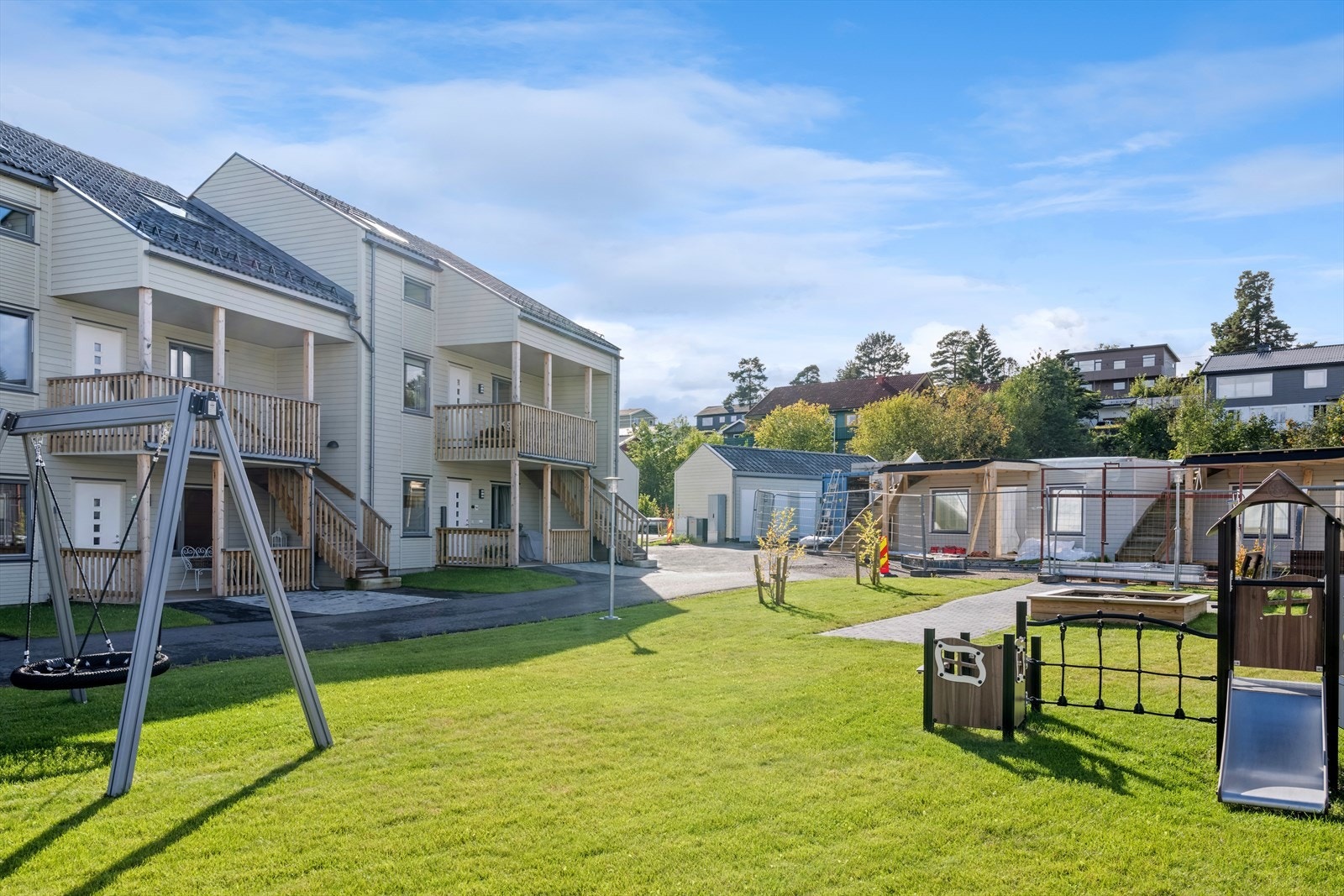 Sameiet har ett hyggelig fellesareal med lekeapparater for barna Galleribilde