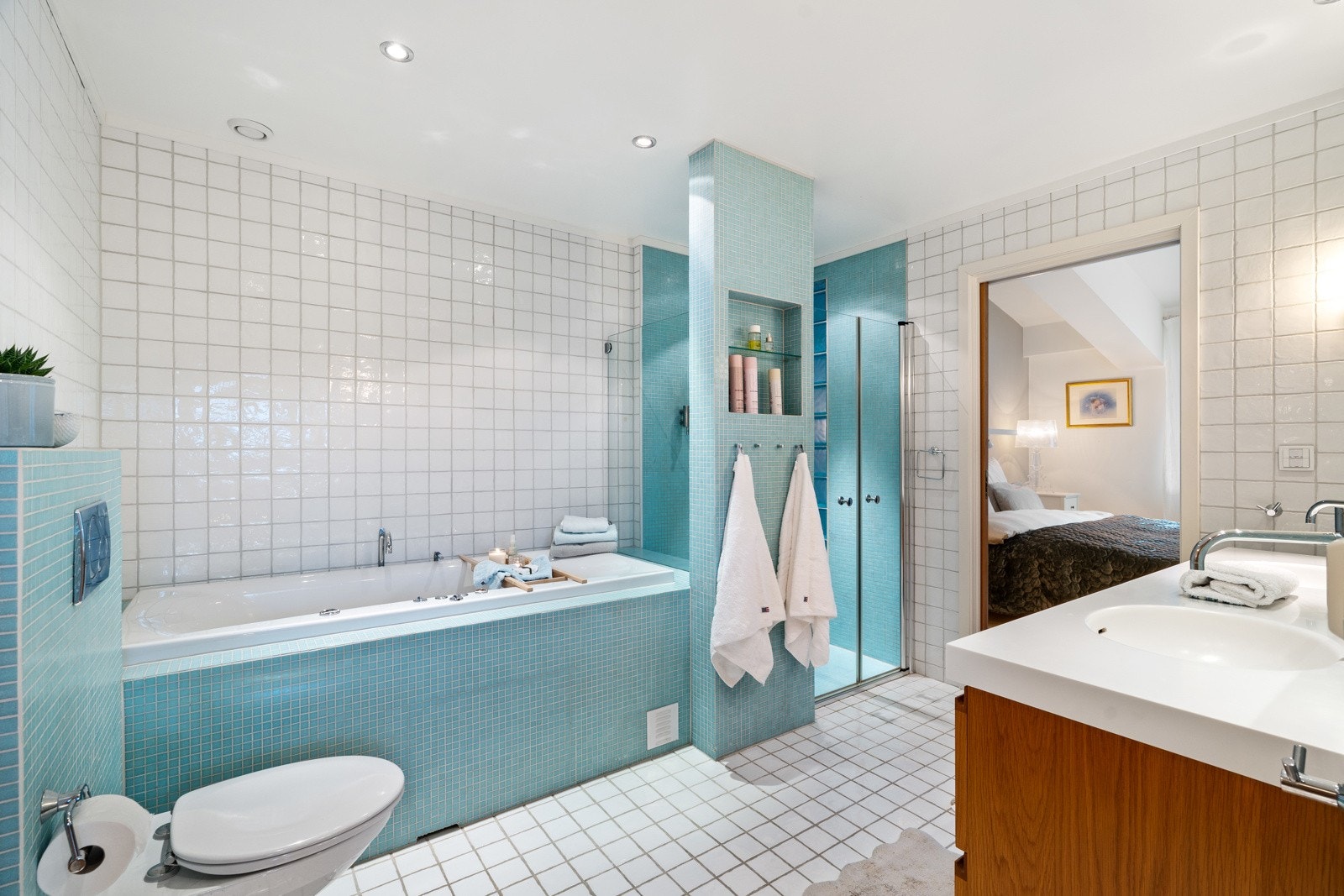 Badet er utstyrt med dobbelservant, badekar og dusjhjørne med innfellbare glassdører. Galleribilde