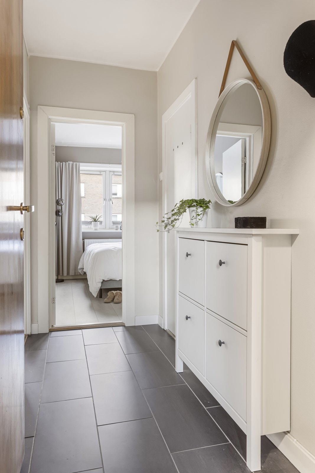 Innbydende og lys entrè med direkte inngang til enkel garderobenisje. Galleribilde