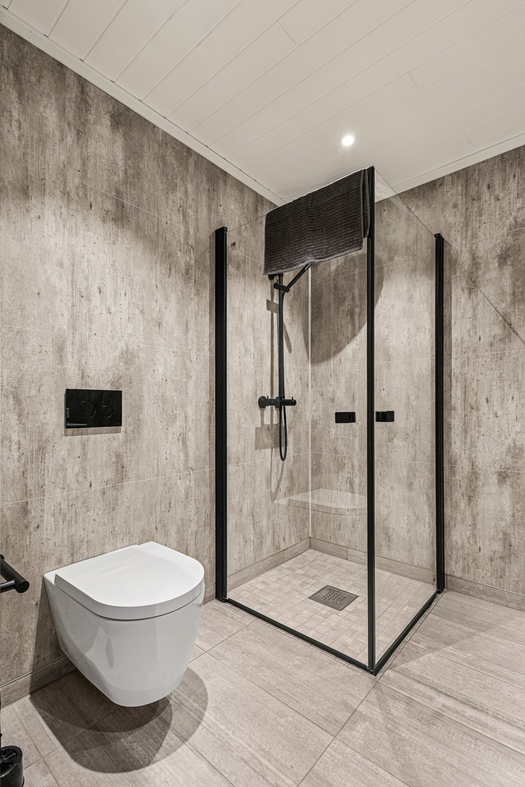 Det er fliser på gulv med gulvvarme og baderomsplater på vegg. Galleribilde