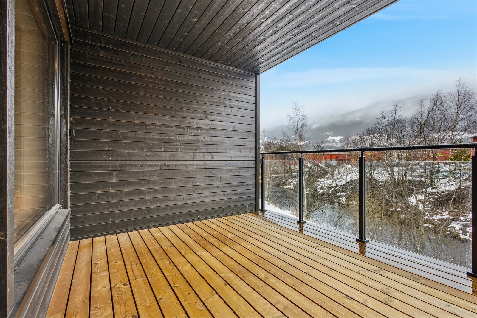Balkongen har moderne preg med glassrekkverk og flott utsikt over elva Våla. Galleribilde