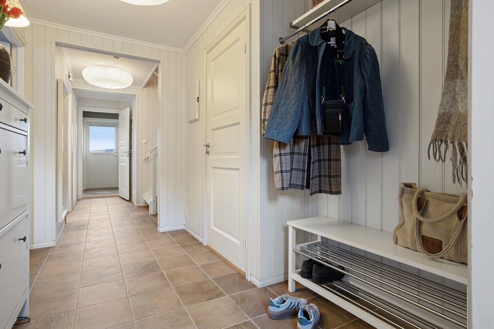 Lys og romslig entre/gang med flislagt gulv med varmekabler og garderobeplass. Galleribilde