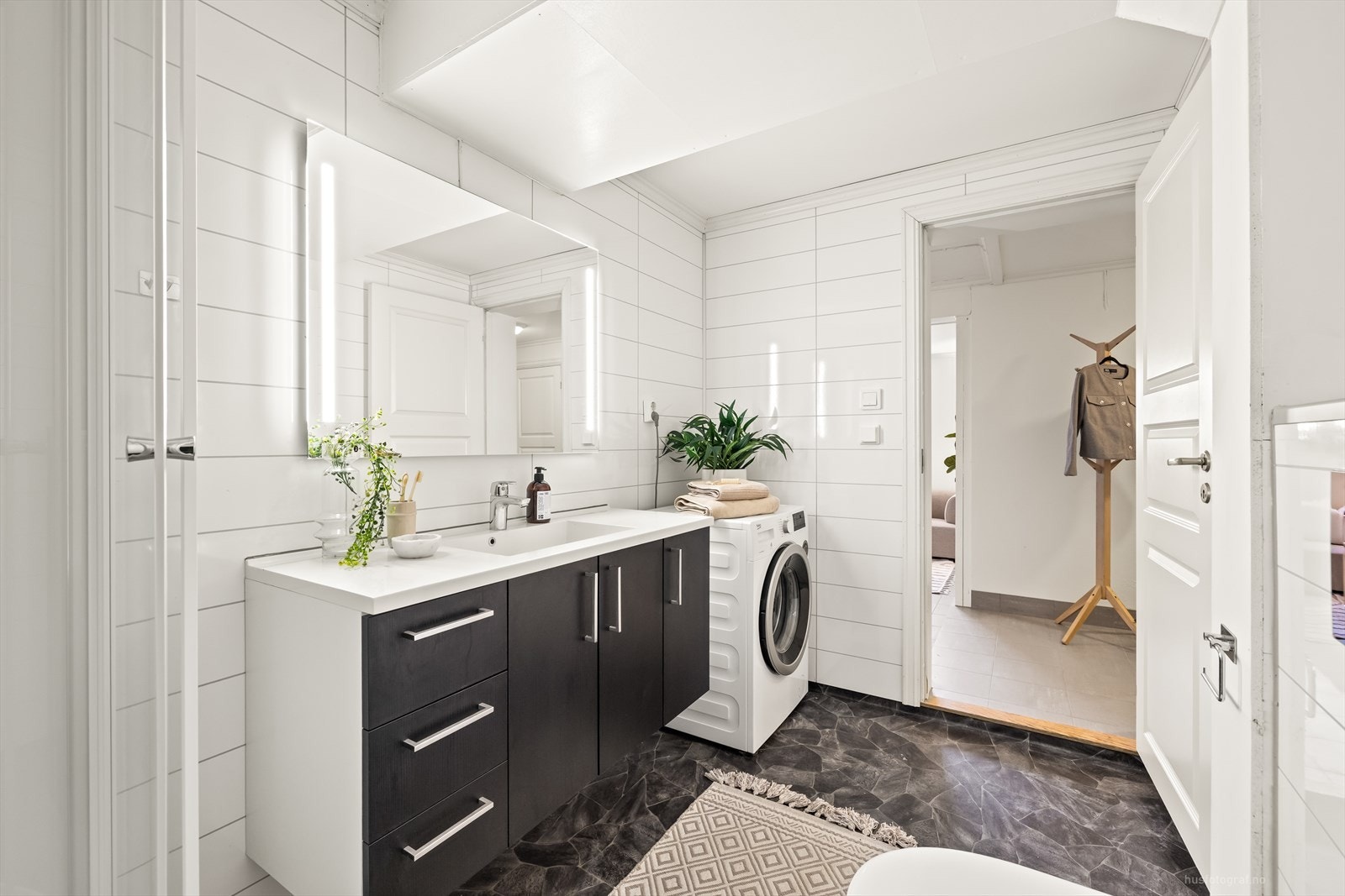 Veggene er kledd med baderomsplater, og taket har malte gipsplater som gir et lyst og rent uttrykk. Galleribilde