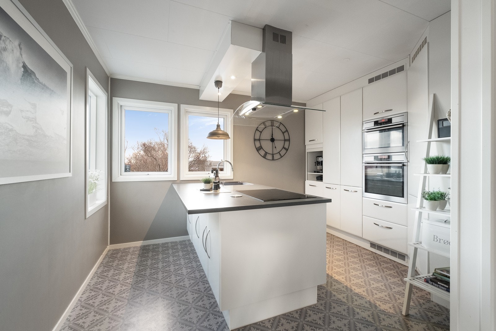 Kjøkkenet har integrerte hvitevarer og en praktisk kjøkkenøy. Store vinduer gir godt med naturlig lys og utsikt mot uteområdet. Galleribilde