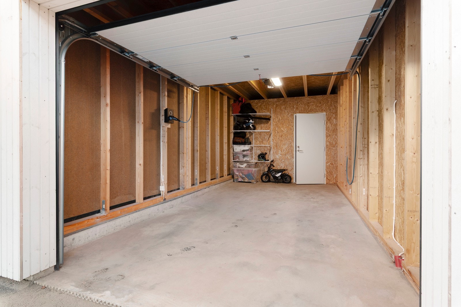 Garasjen har automatisk port, montert elbillader og bod i bakkant. Galleribilde