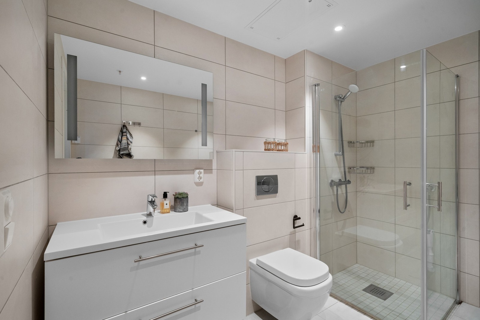 Delikat baderom med gulvvarme og opplegg for vaskemaskin Galleribilde