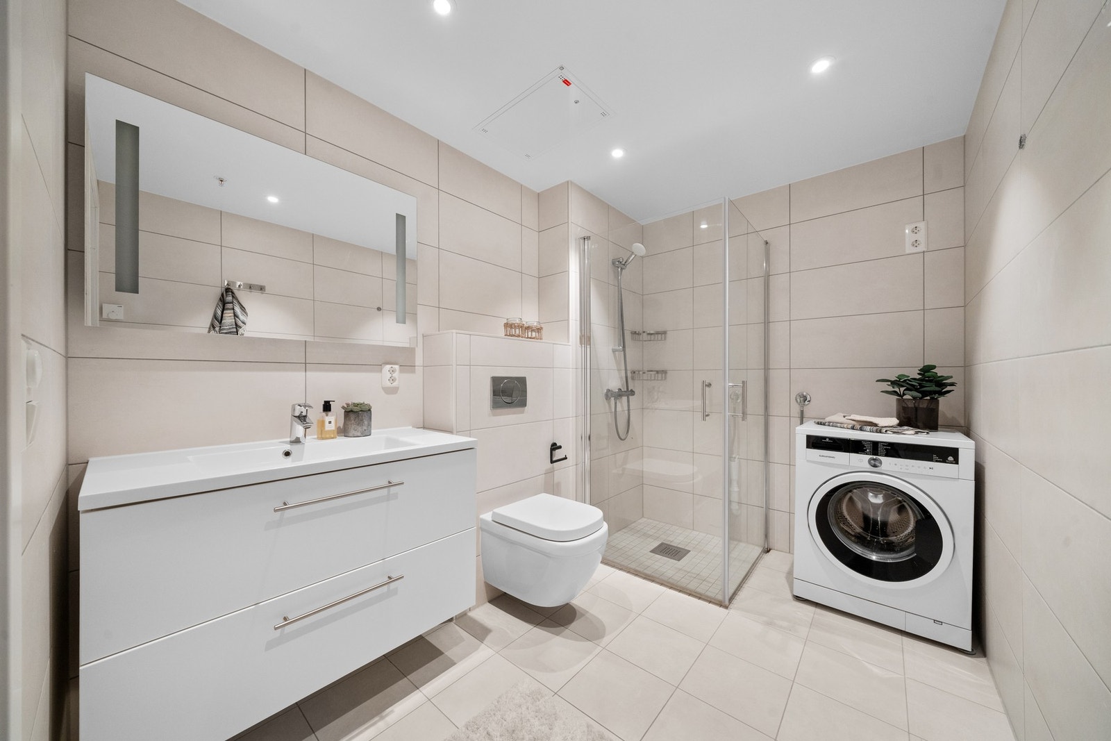 Delikat baderom med gulvvarme og opplegg for vaskemaskin Galleribilde