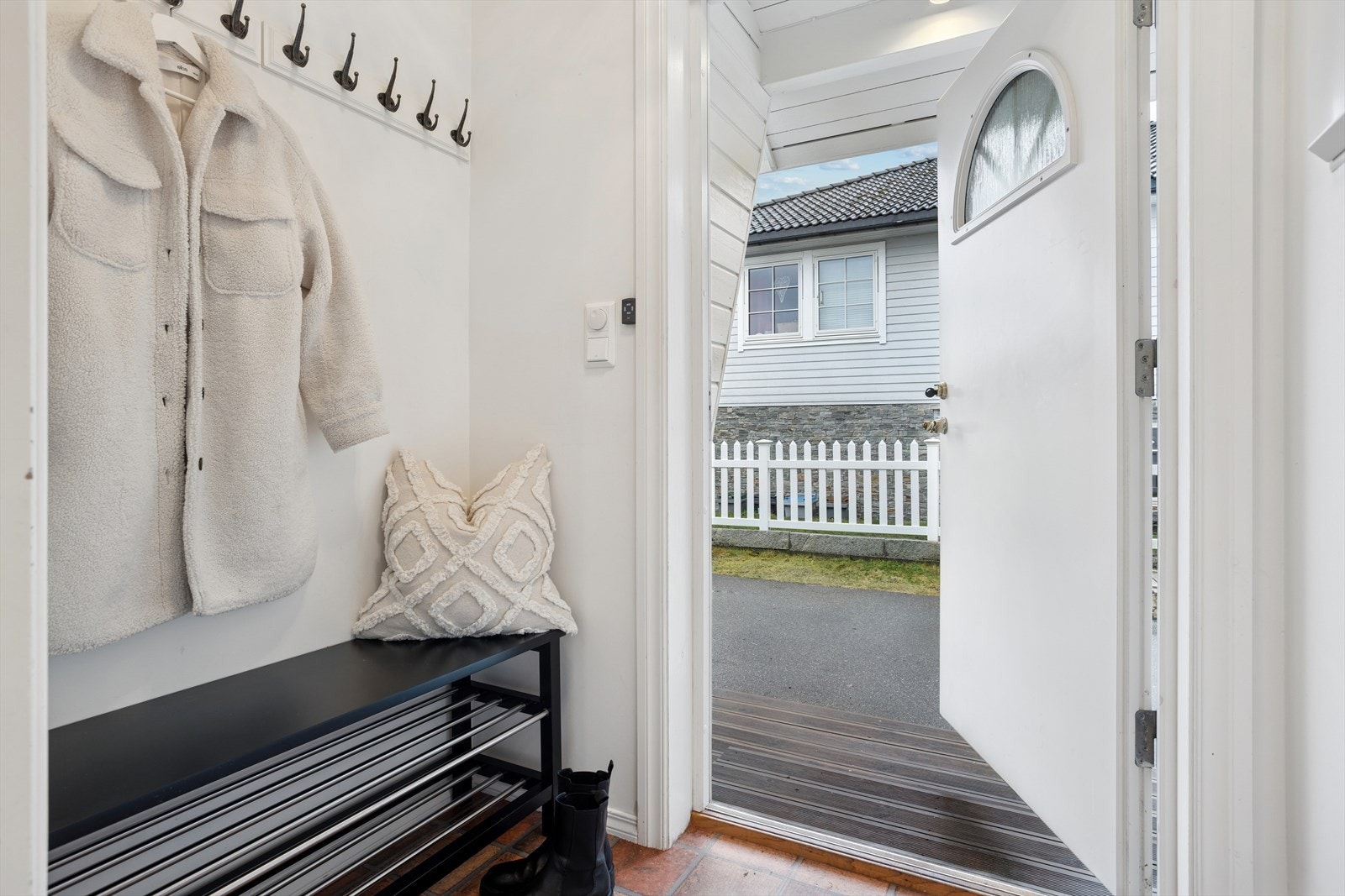 Inngangsdøren har overbygg som gir god beskyttelse mot vær og vind. I første etasje møtes du av et lyst og pent vindfang og god plass til yttertøy. Galleribilde