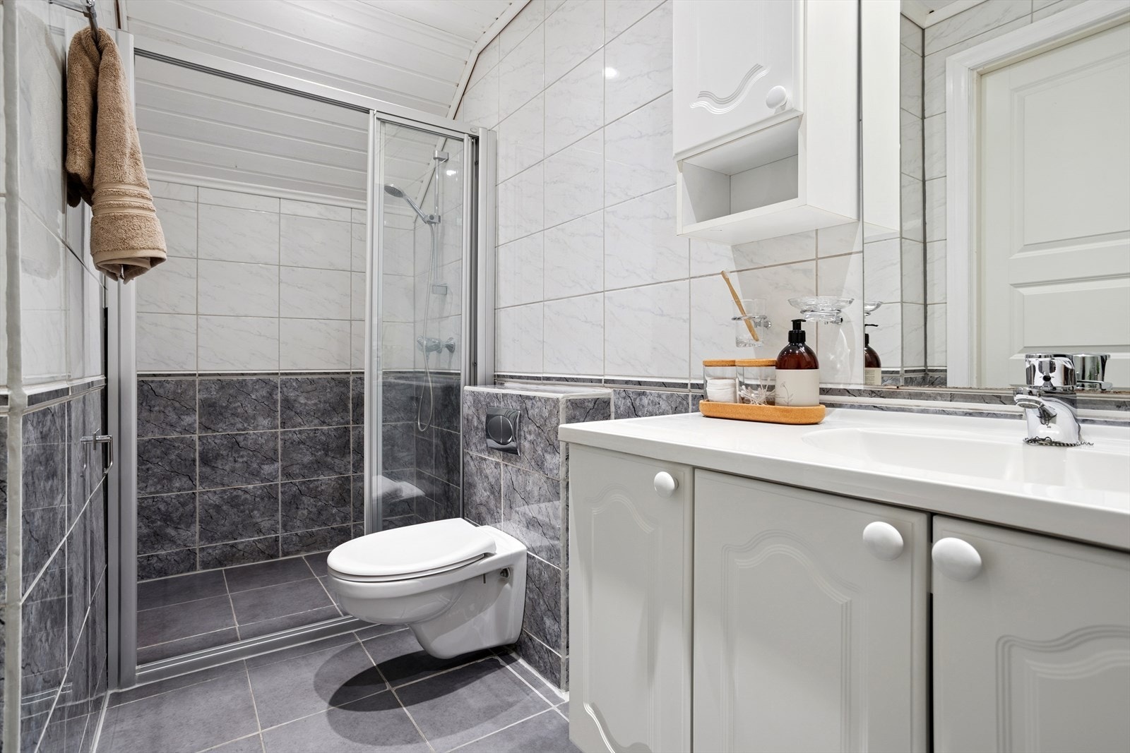 Gulvet er flislagt, og veggene har fliser som gir et klassisk uttrykk. Rommet har balansert ventilasjon og luftespalte for tilluft, noe som sikrer god luftsirkulasjon og et behagelig inneklima. Galleribilde