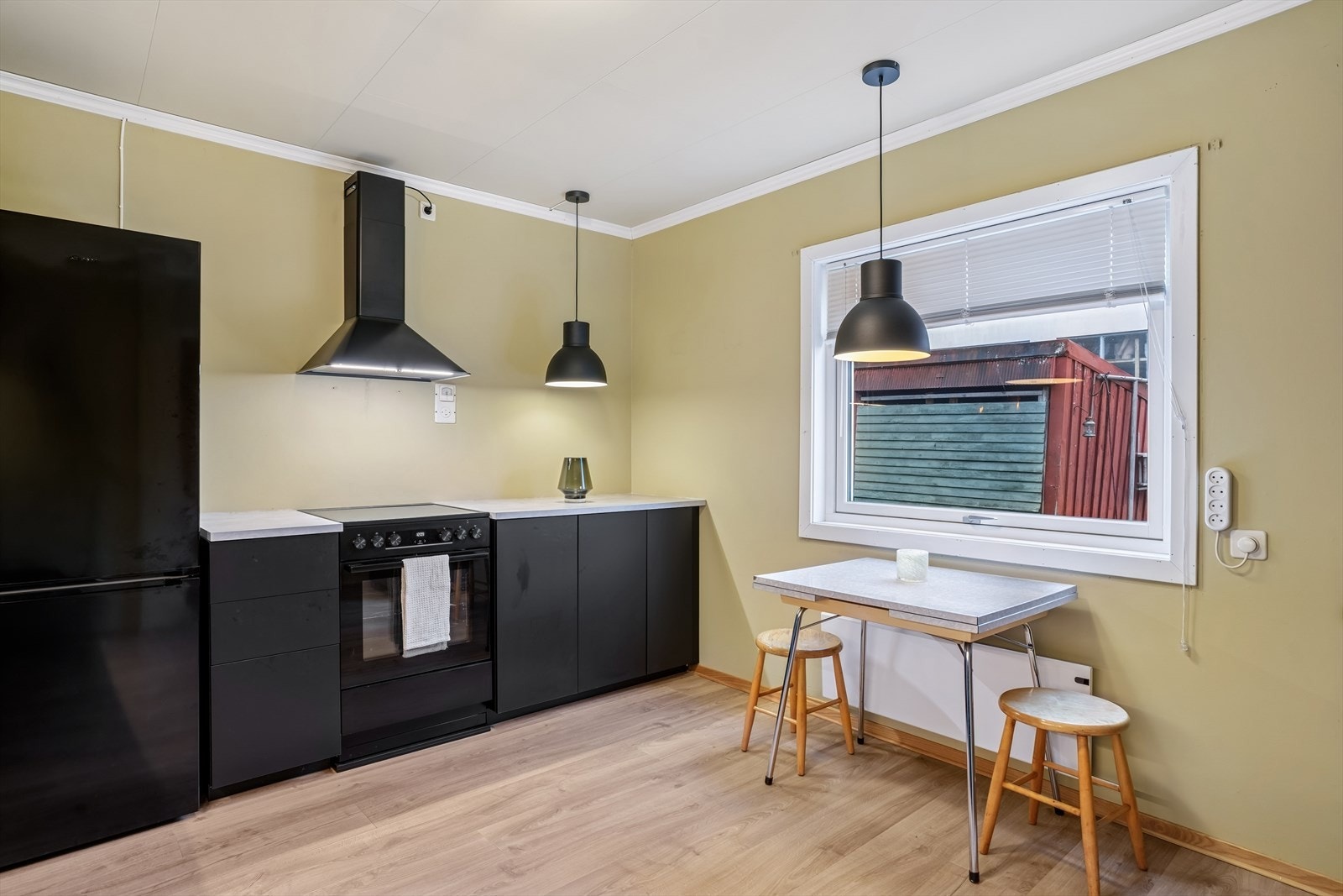 Kjøkkeninnredningen er fra IKEA. har sorte slette fronter, benkeplate av laminat og oppvaskkum. Galleribilde