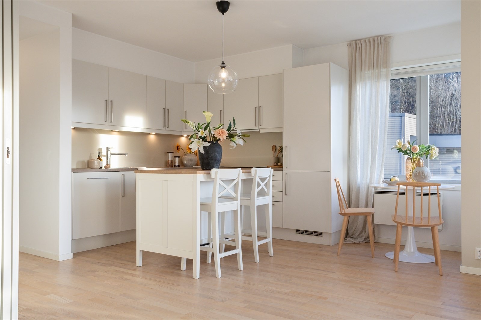 Praktisk kjøkkenøy med sitteplasser kombinert med et koselig spisehjørne - perfekt for både raske måltider og hyggelige stunder. Galleribilde