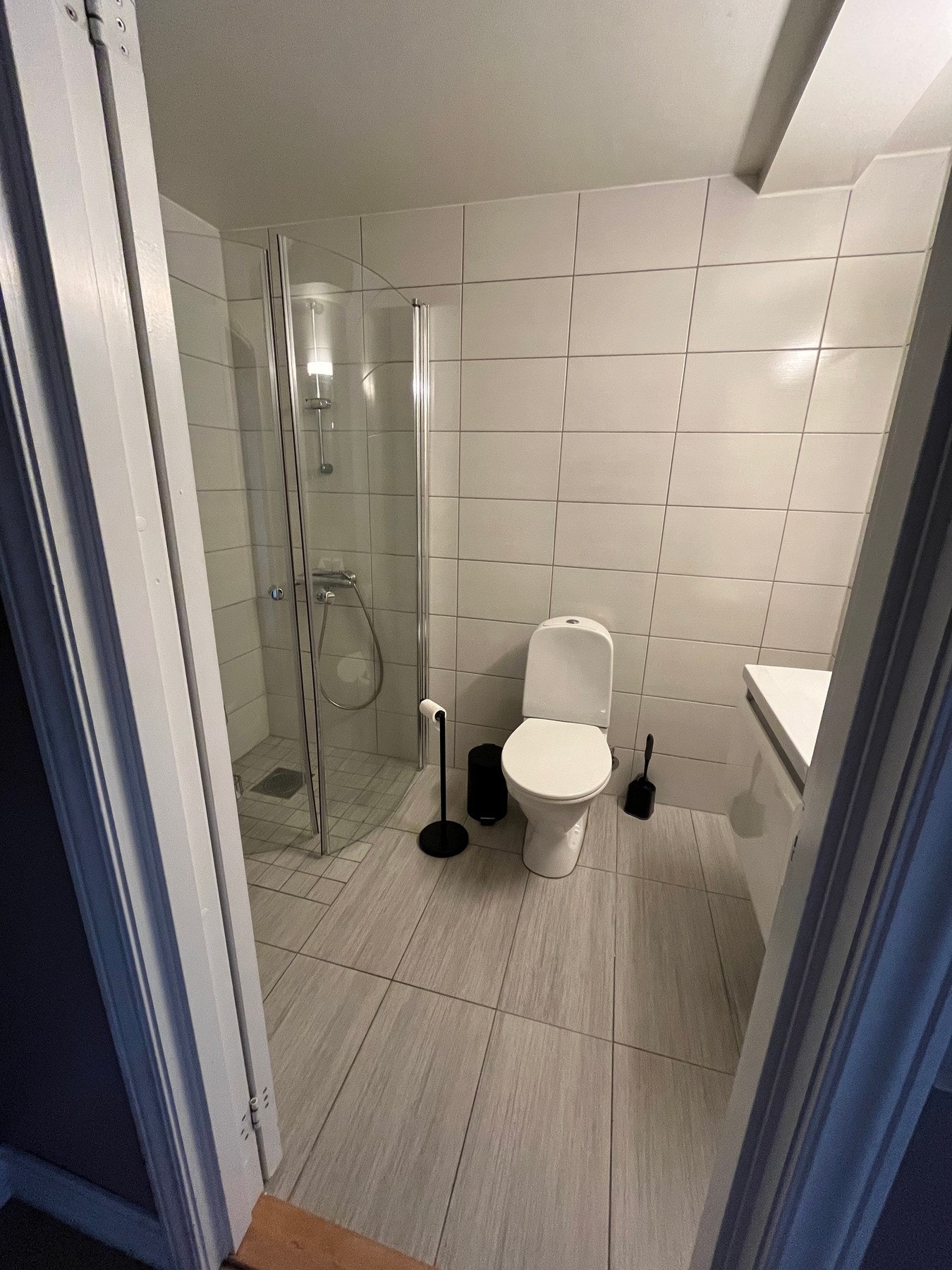 Flislagt bad med dusjnisje og opplegg for vaskemaskin. Galleribilde