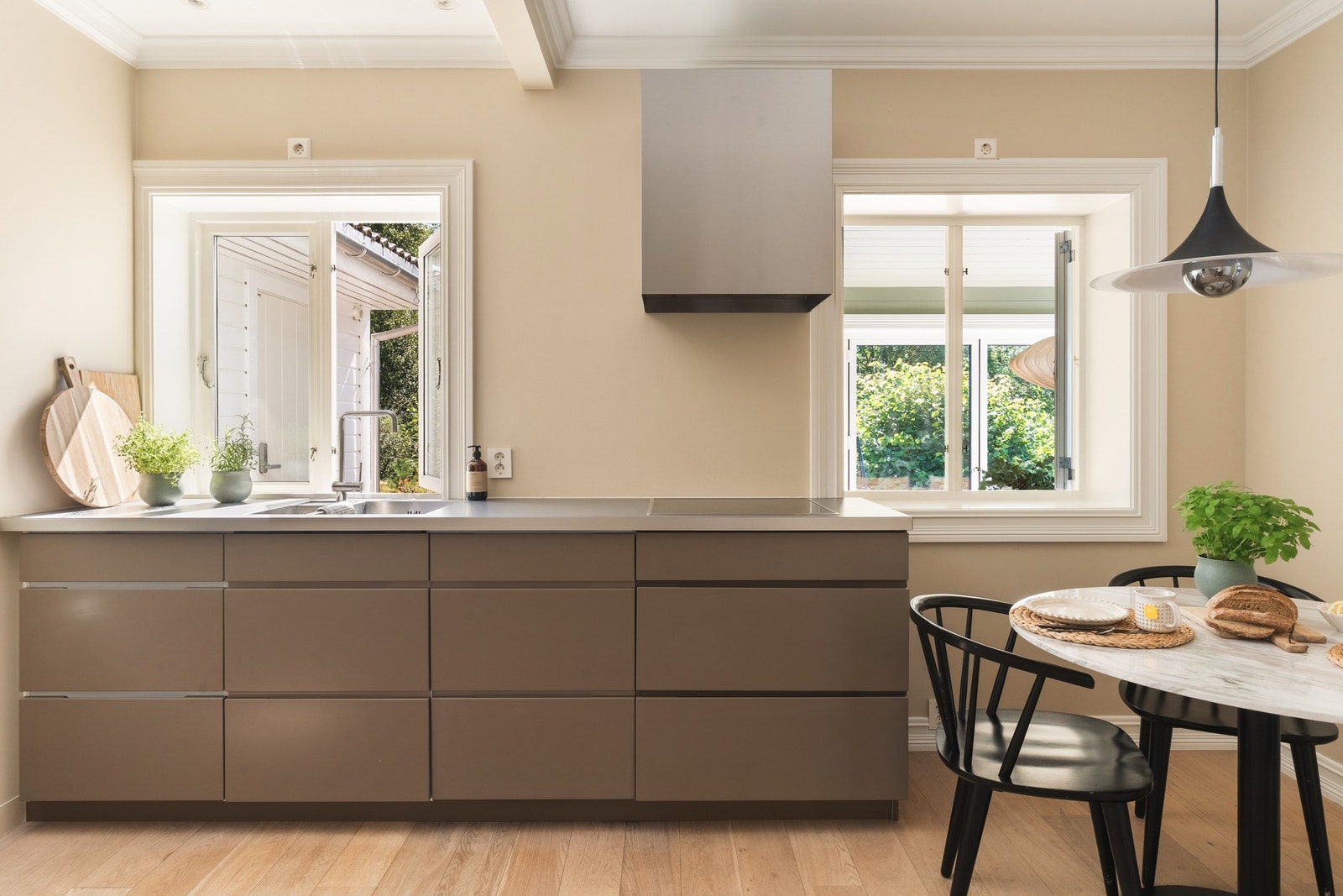 Kjøkken har slette fronter og integrerte hvitevarer som komfyr, ovn, kjøleskap og kaffemaskin. Galleribilde