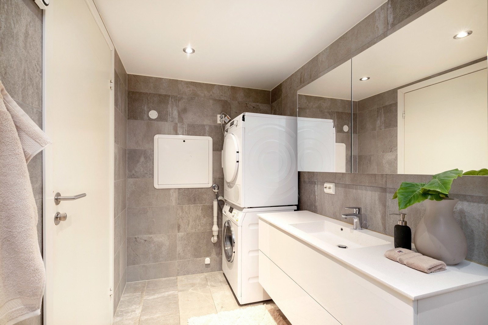 På badet er det blant annet badekar, vegghengt toalett, baderomsinnredning og opplegg til vaskemaskin og tørketrommel Galleribilde