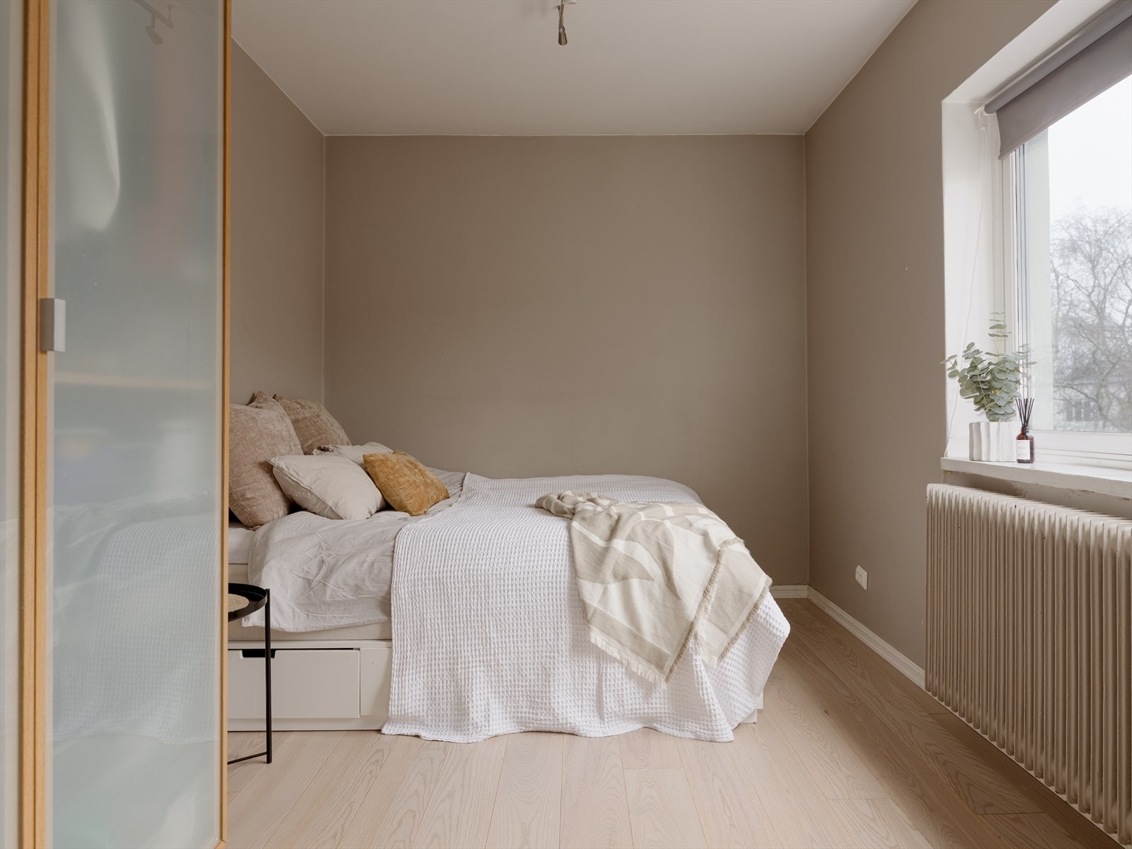 Leiligheten har to romslige soverom med farger som harmonerer med resten - beige vegger og lys parkett. Galleribilde