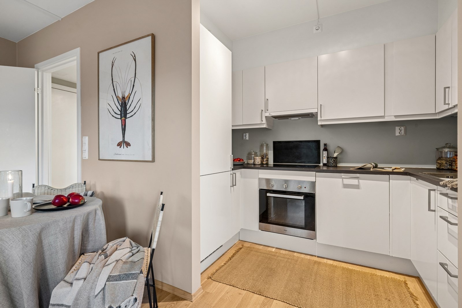 Kjøkkenet fremstår som tidsriktig og stilrent med lyse og glatte fronter. En god kombinasjon av skap og skuffer gir mye oppbevaringsplass og gode arbeidsflater. Galleribilde