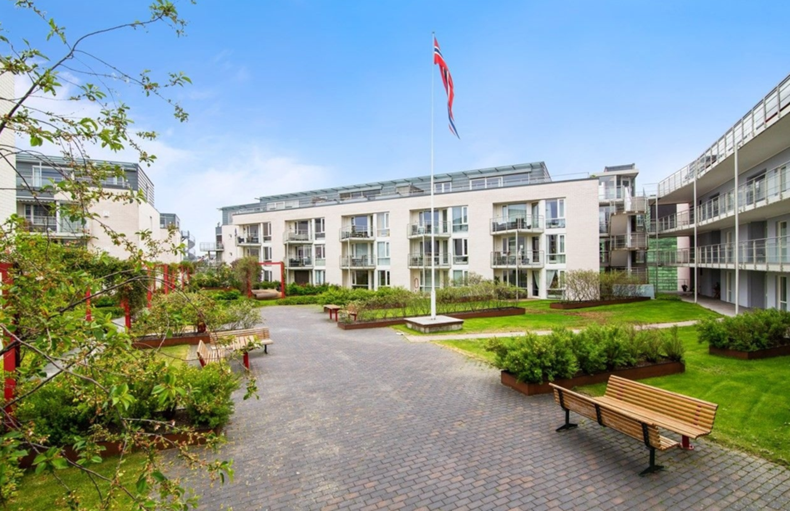 Felles takterrasse med plenareal, prydbusker og sittegrupper. Galleribilde