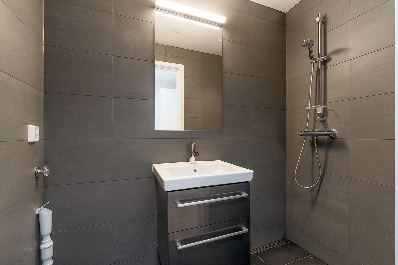 Pent flislagt bad med opplegg for vaskemaskin og varmekabel i gulv. Galleribilde