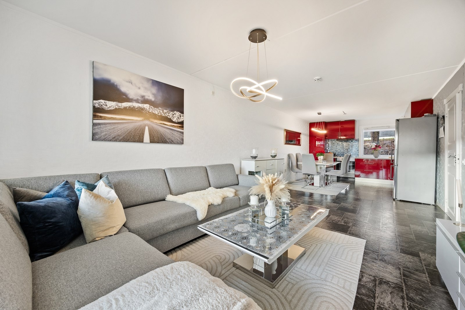 Leiligheten har en åpen løsning mellom stue og kjøkken som skaper en sosial og luftig sone. Galleribilde