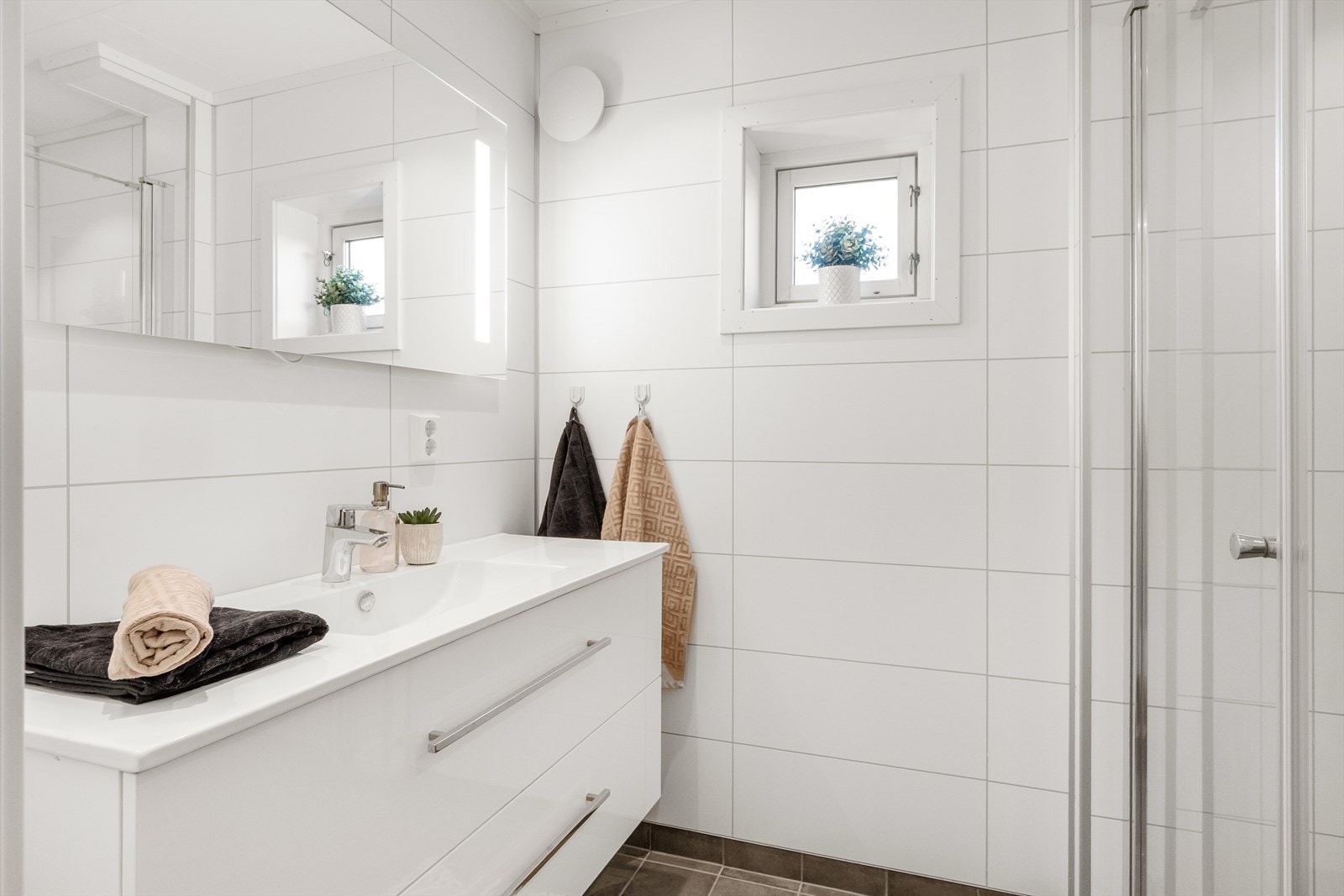 Pent bad oppgradert i 2021 med baderomsplater på vegger, malte plater med downlights i himling og fliser på gulv med gulvvarme. Galleribilde