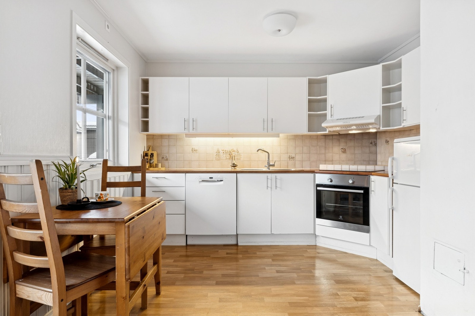 Kjøkkenet er utbygget med god skap- og benkeplass. Det er glatte kjøkkenfronter og fliser over benkeplate i laminat Galleribilde