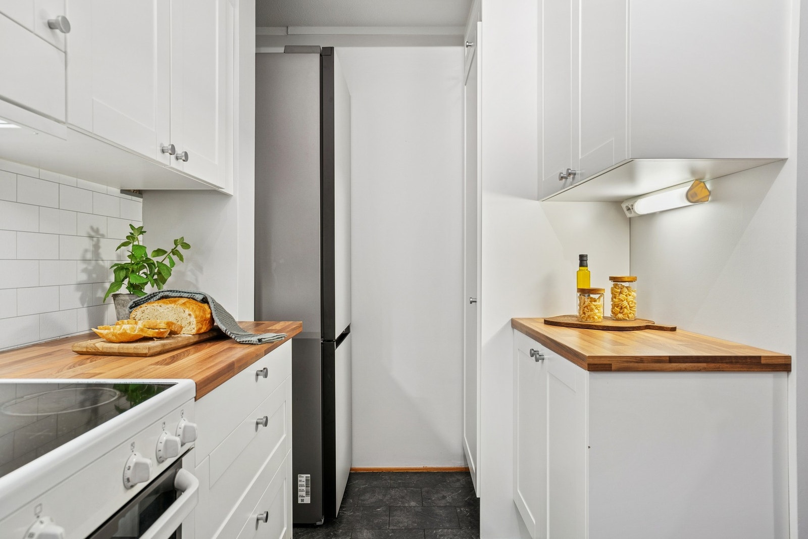 Praktisk kjøkken delvis skjult fra stuen hvor både oppvaskmaskin og komfyr medfølger Galleribilde