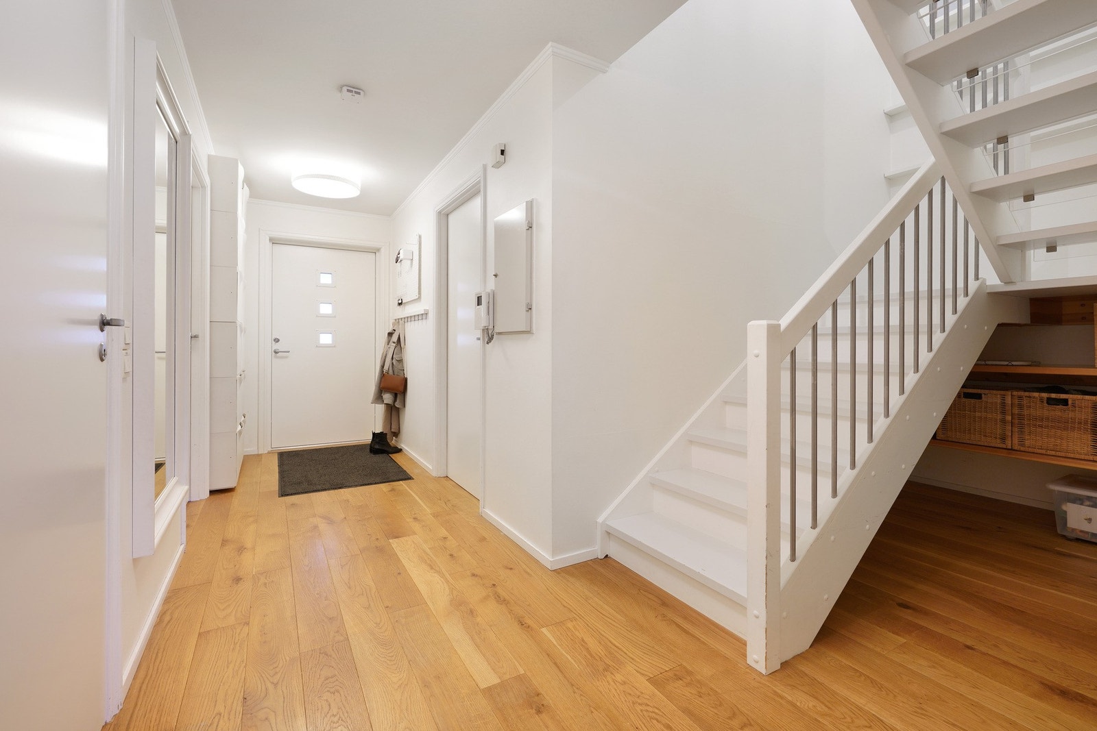 Inngangsparti med god plass til å henge fra seg yttertøy og lagringsplass under trapp Galleribilde