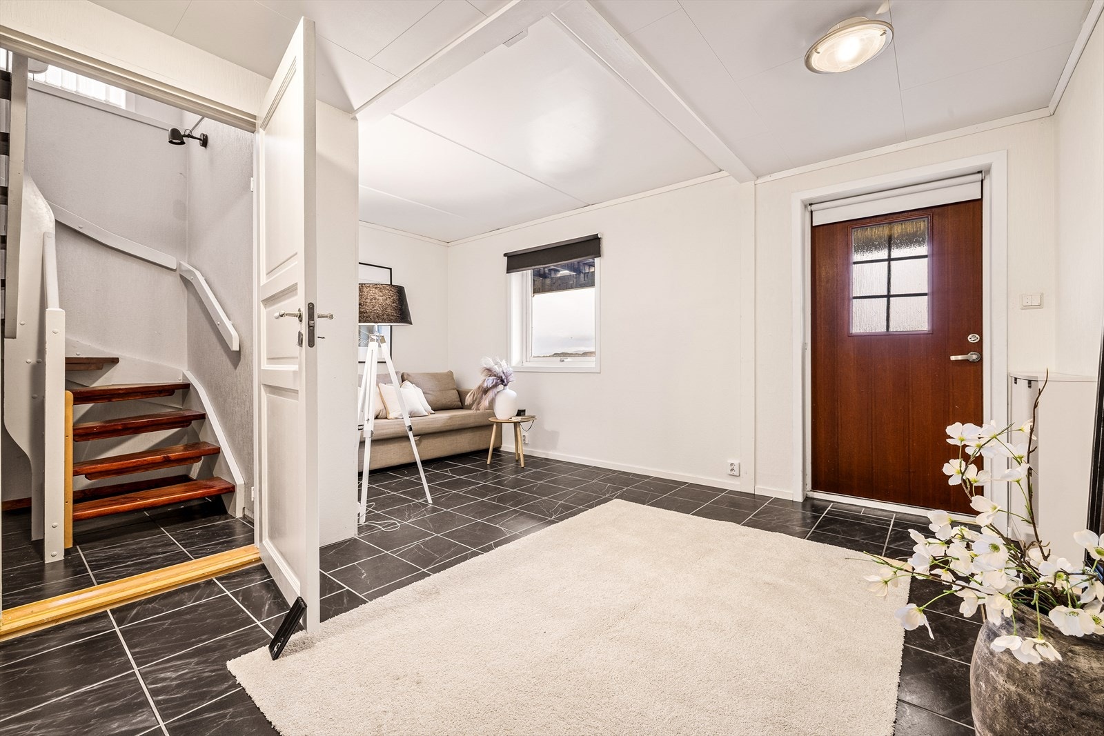 Stor hall ved inngangspartiet. Egner seg ypperlig som kjellerstue, men kan også innredes med ekstra soverom dere sofaen står. Galleribilde