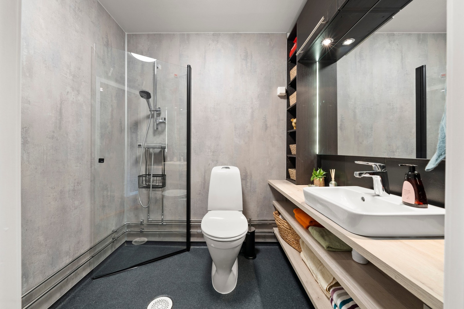 Badet har eldre slukløsning og er overflateoppusset i 2025. Rommet har belegg på gulv, baderomsplater på vegger samt hvitmalt, slett tak. Det er installert reflektorovn og taklampe. Det er gjennomgående et fagmessig preg på utførelsen. Galleribilde