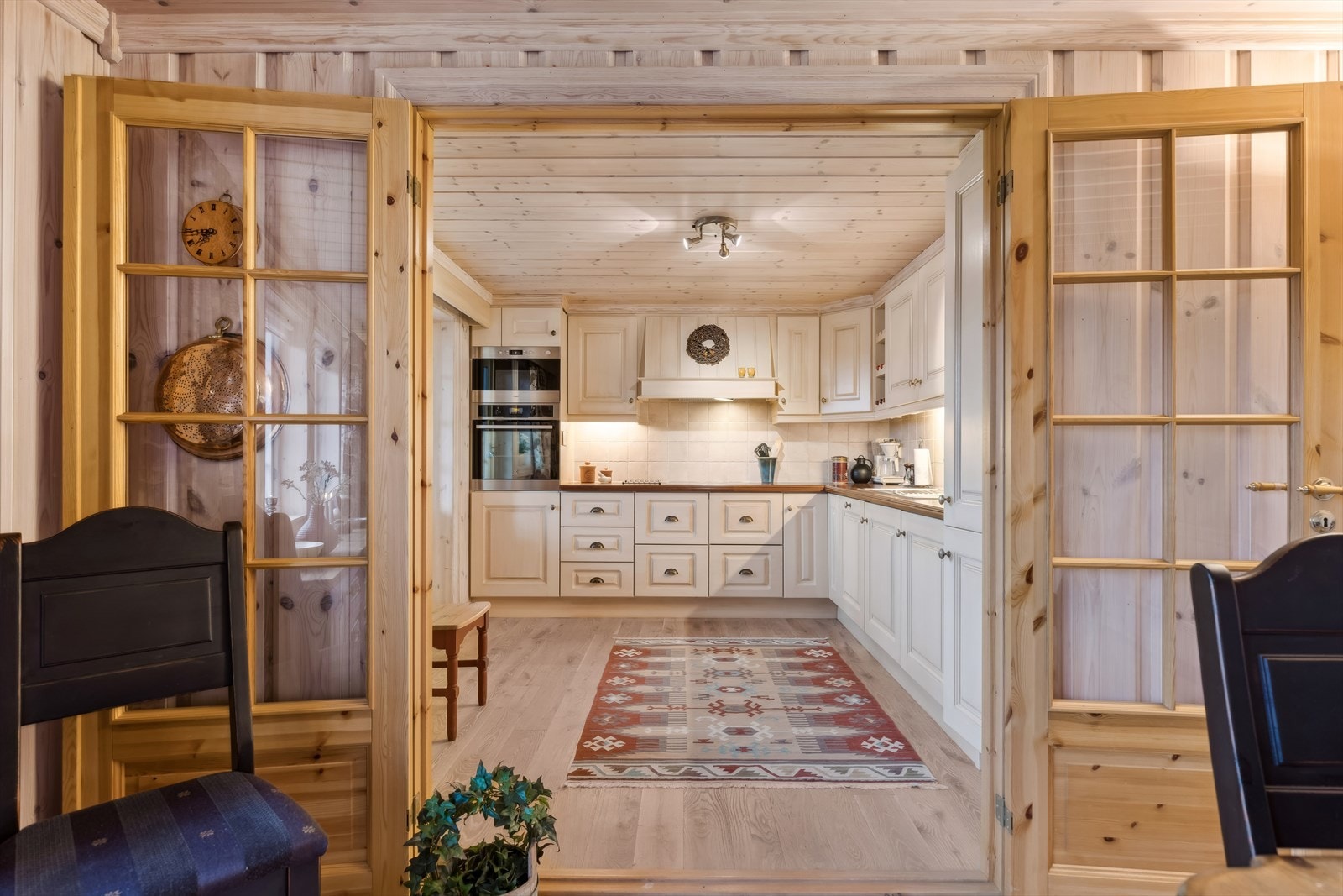 Kjøkkenet ligger strategisk plassert mot spisestuen, med adkomst via tofløyede dører med glassinnslag. Galleribilde