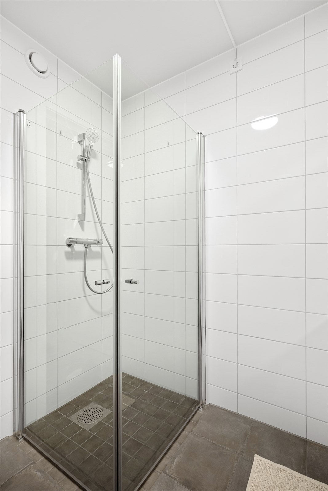 Flott helfliset bad med vegghengt toalett og dusjhjørnet. Galleribilde