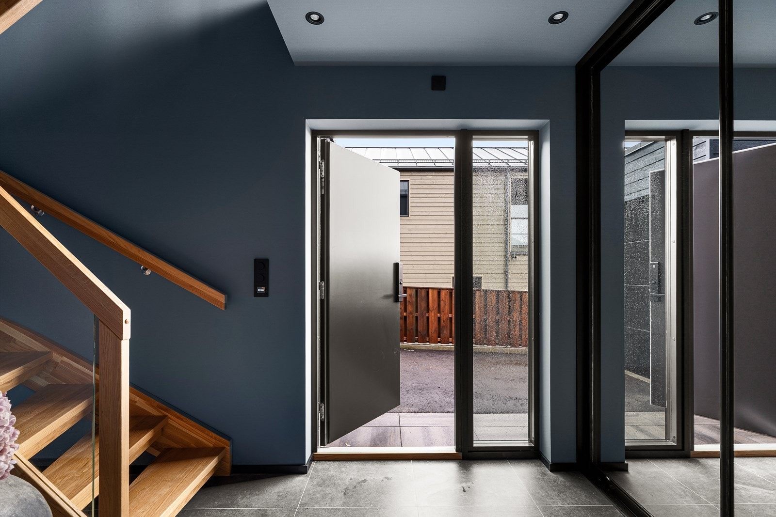 En luftig gang med fliser på gulv og vegger/himling malt i tidsriktige fargevalg. Stor skyvedørsgarderobe langs hele den ene veggen med god plass til og henge fra seg yttertøy og sko. Galleribilde