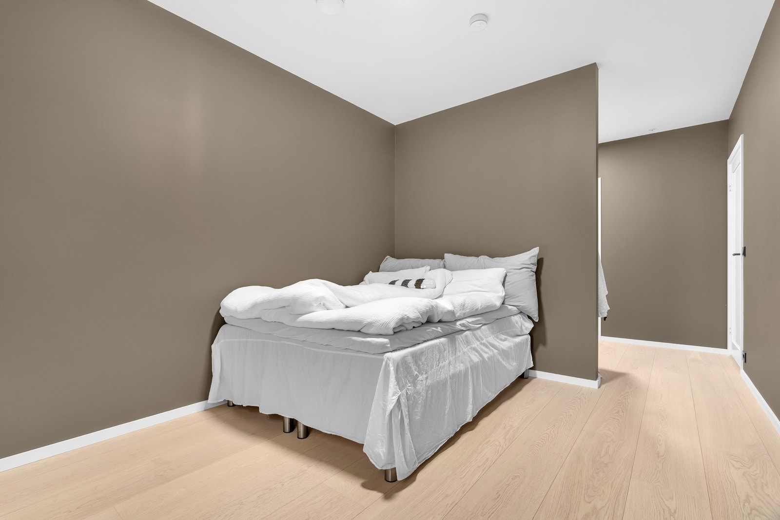 Vegg som danner et koselig hjørne for sengen. Galleribilde