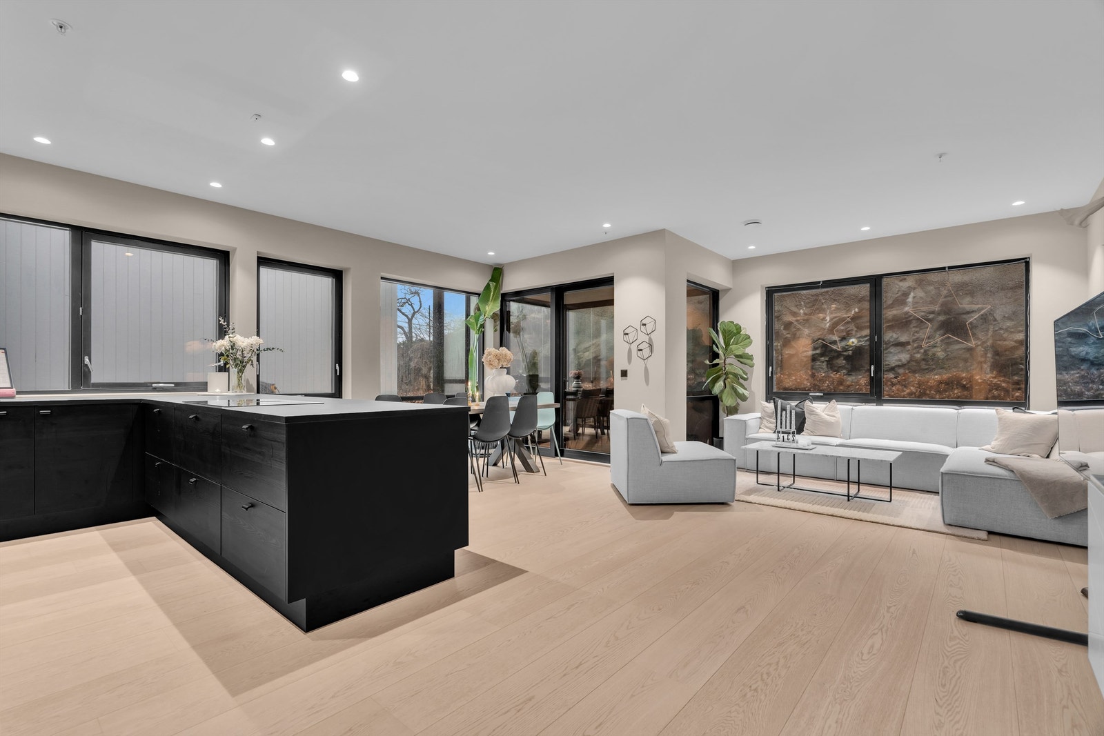 Lys stue med store vindusflater som slipper inn rikelig med dagslys. Galleribilde