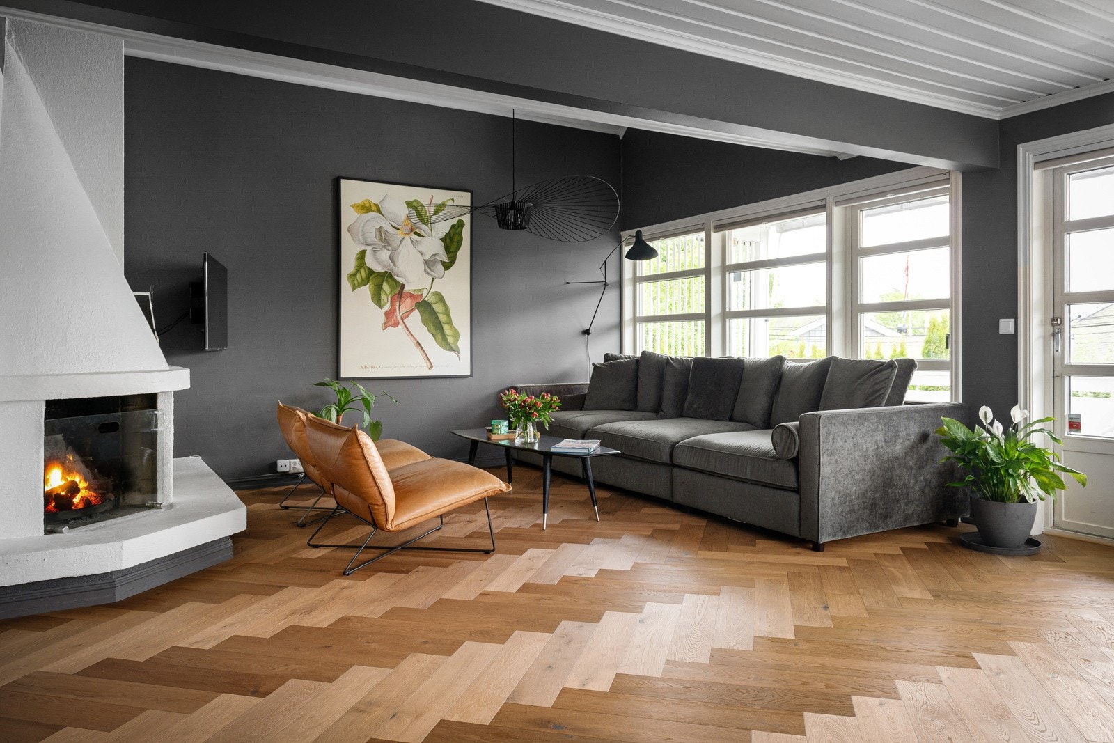 Rommet er innredet med en romslig sofagruppe og en elegant peis som skaper en lun og hyggelig atmosfære Galleribilde