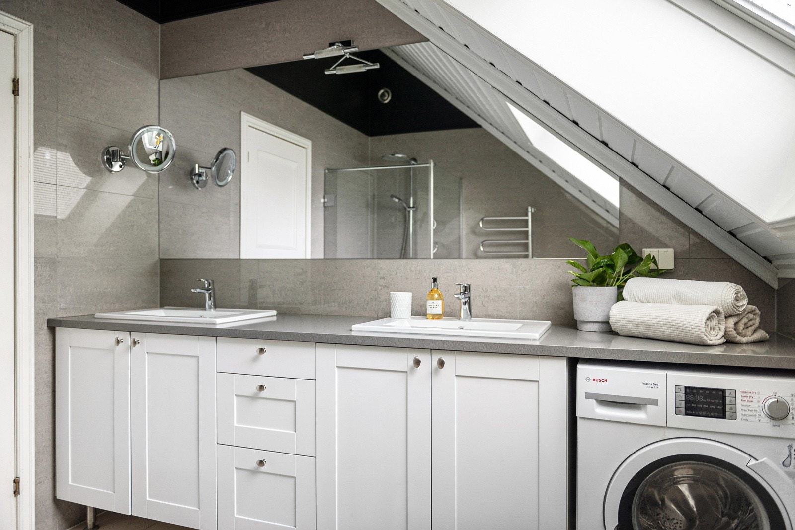 Badet i 2. etasje er fra 2010 og fremstår som lyst og romslig. Innredningen består av en dobbel servant med god skap- og skuffeplass, samt opplegg for vaskemaskin under benken. Galleribilde