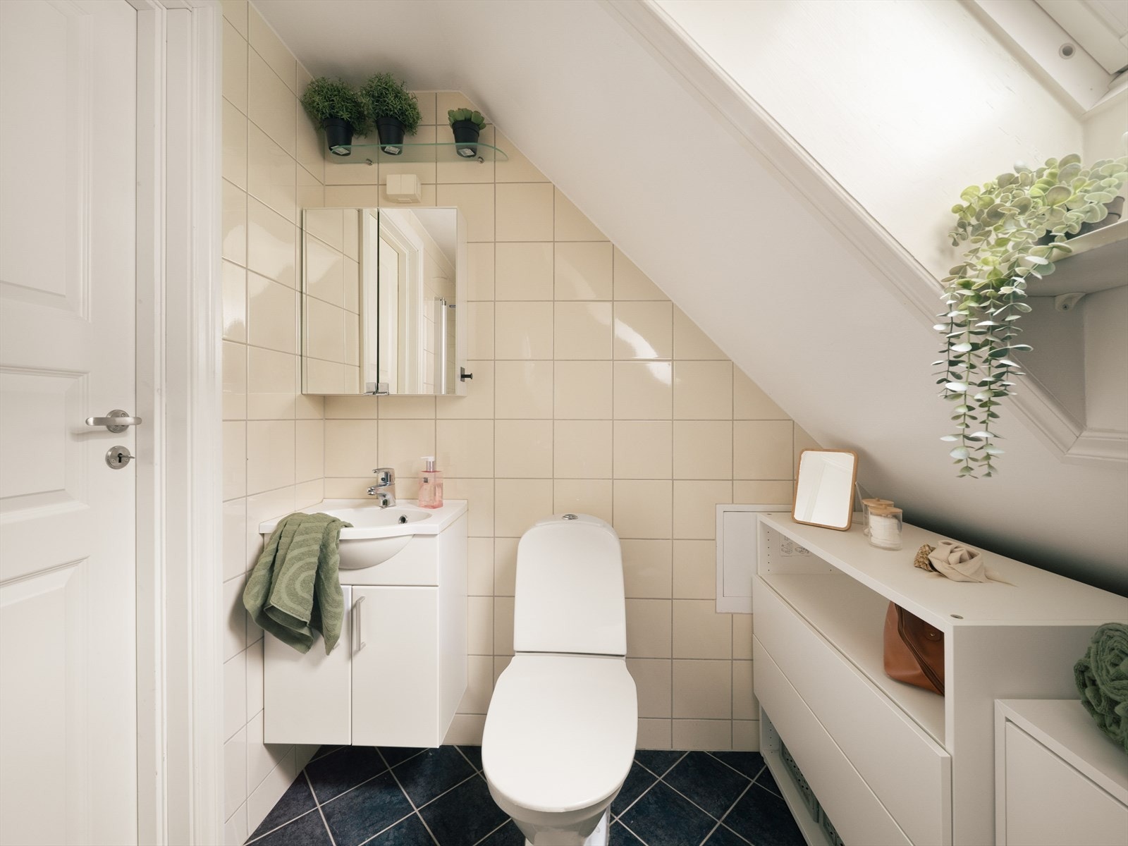 Pent helfliset bad innredet med baderomsinnredning med servant, dusj, toalett og opplegg for vaskemaskin. Galleribilde