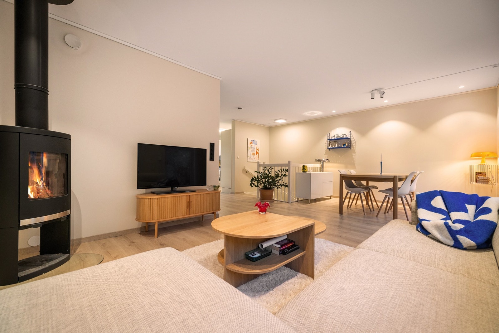 Koselig stue med tilhørende ildsted og plass til både sittegruppe og spisestuebord. Galleribilde