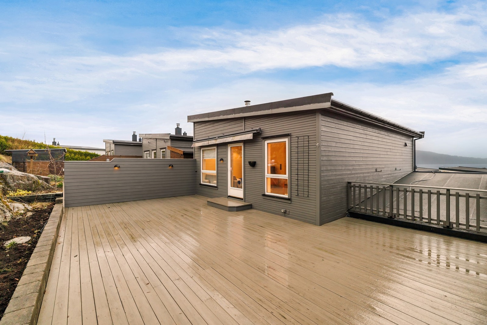 Det er utebelysning på skjermvegg mot tilstøtende nabo og på husets fasade. Galleribilde