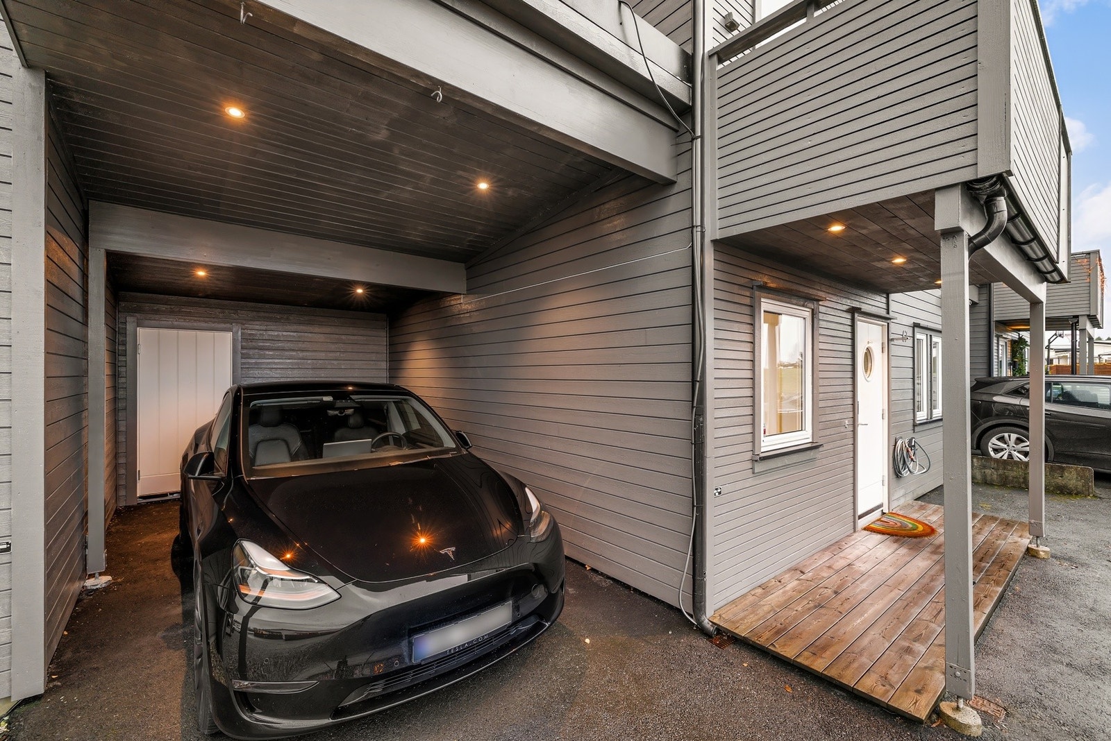 Det er parkering i carport med sportsbod i bakkant. Galleribilde